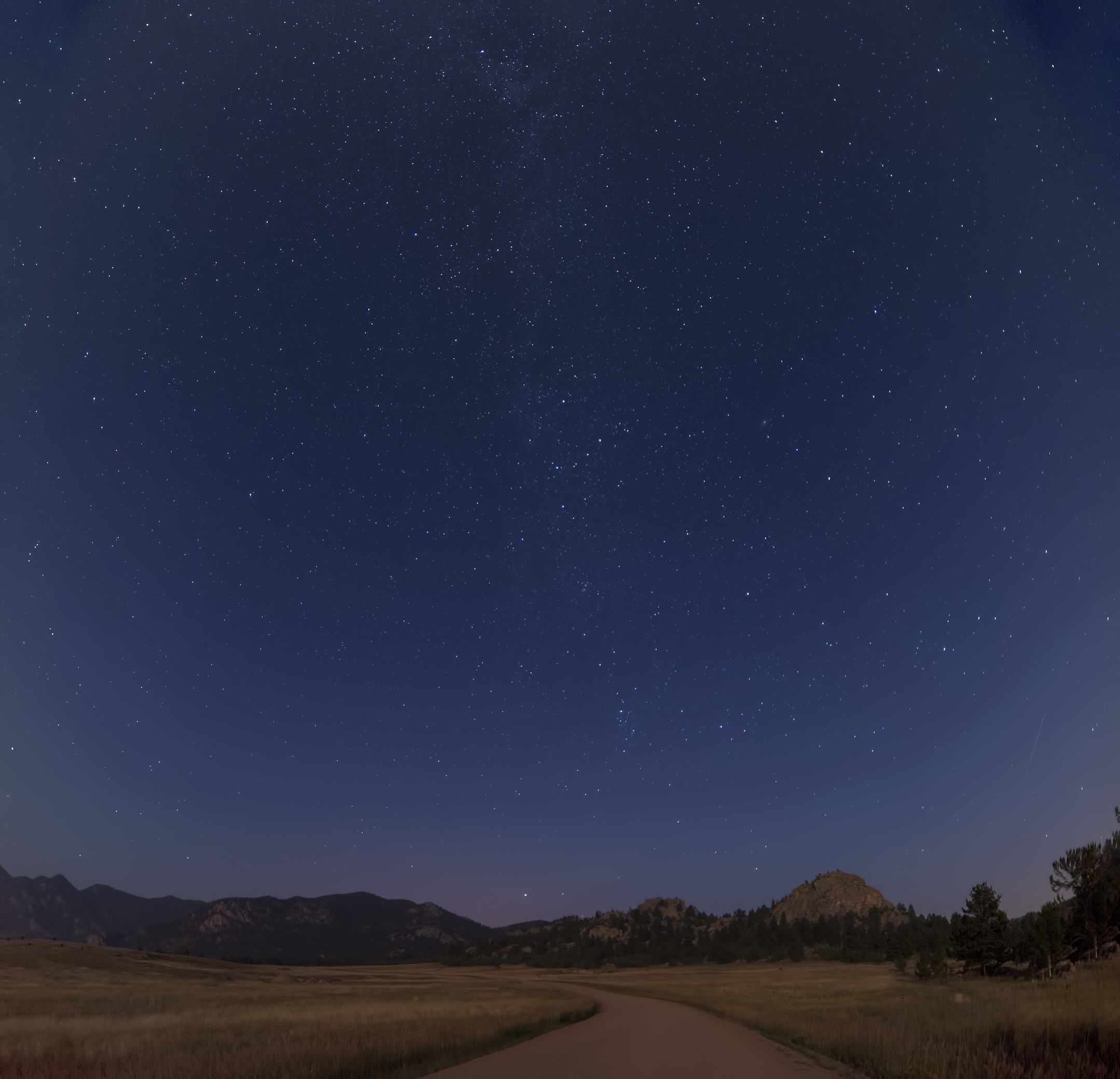 A winding Colorado road beneath a starry night sky