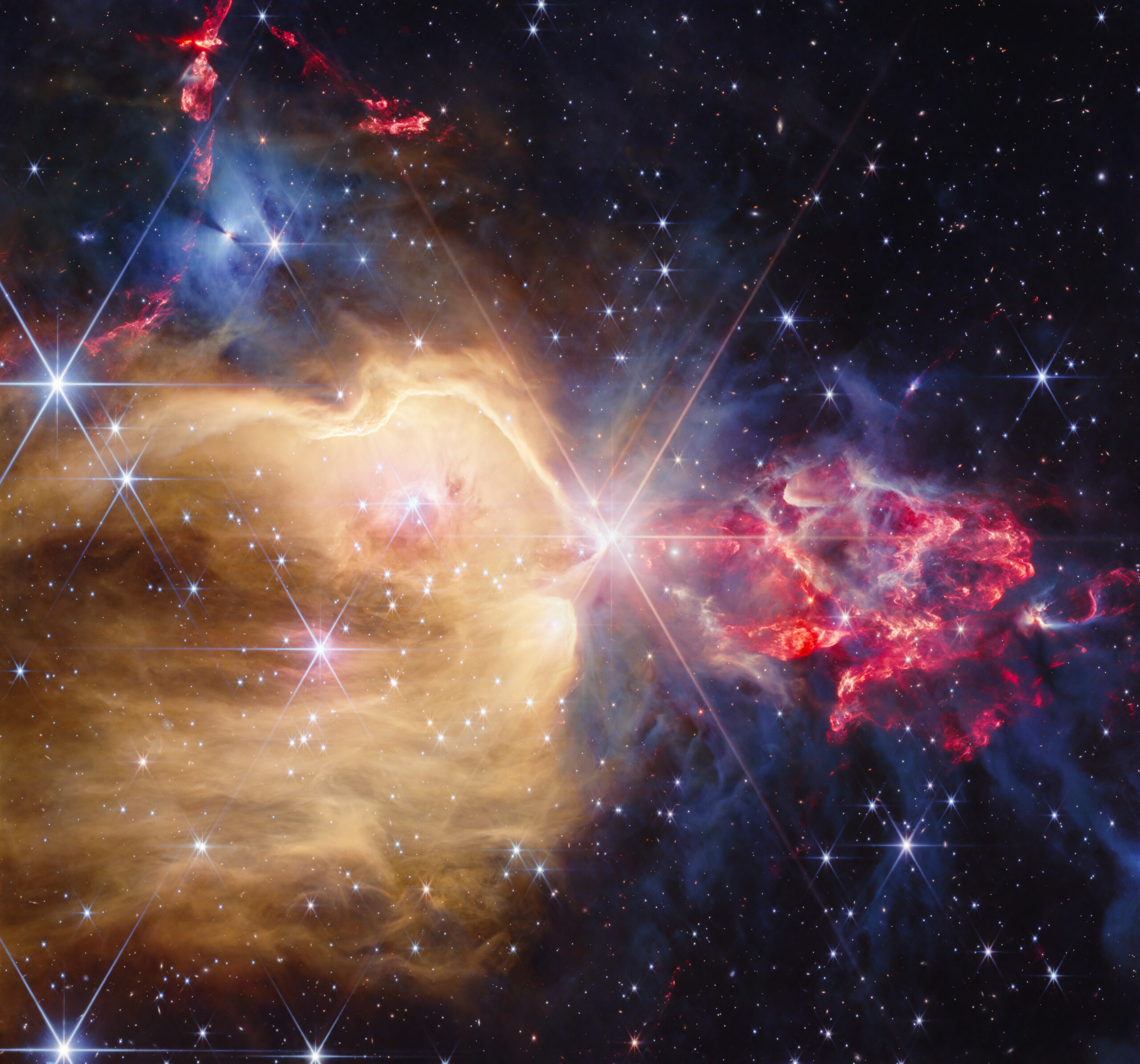 Young stars amid golden gas, red outflows and dense gray clouds in NGC 7129.