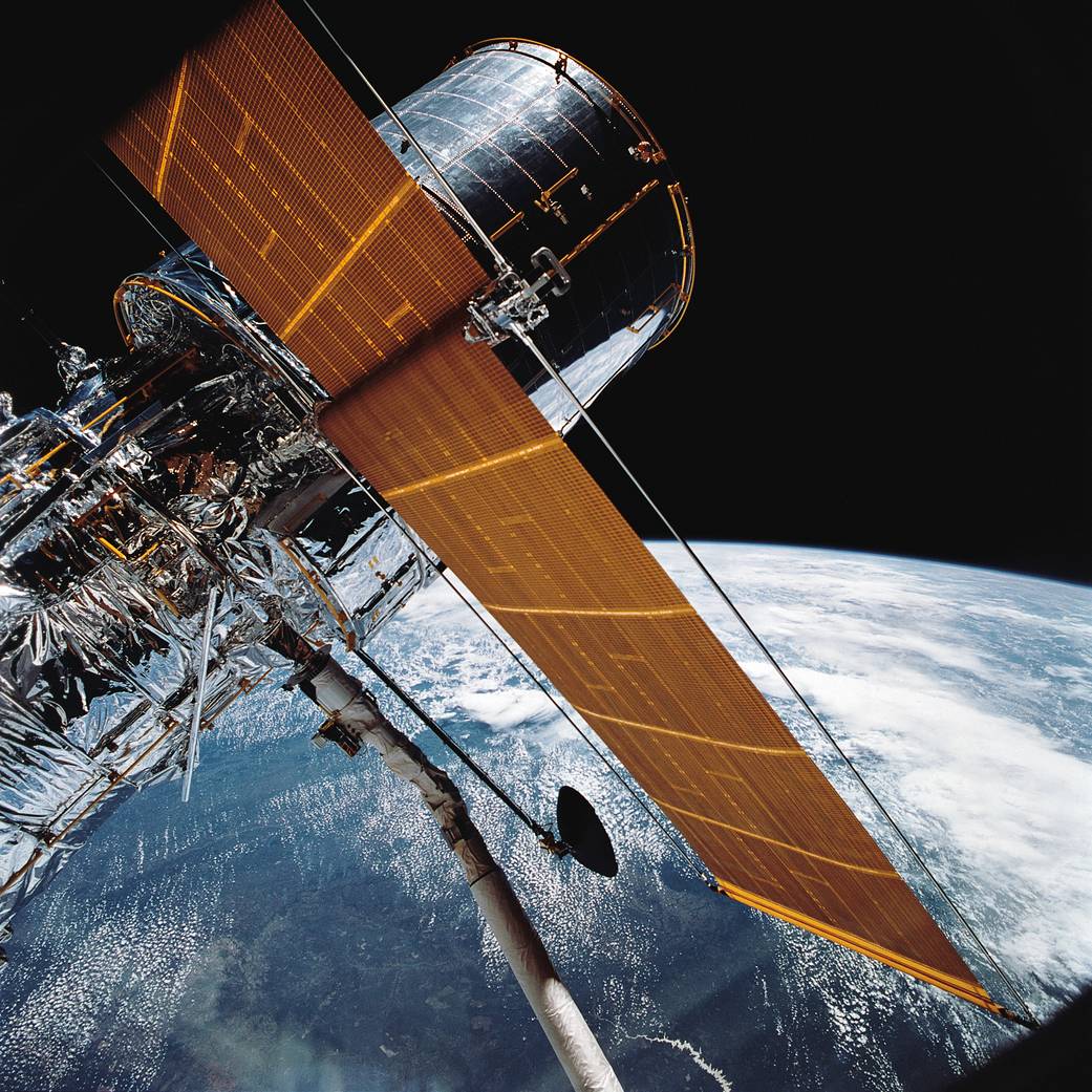 The Hubble Space Telescope suspended above Earth during deployment from the space shuttle Discovery.