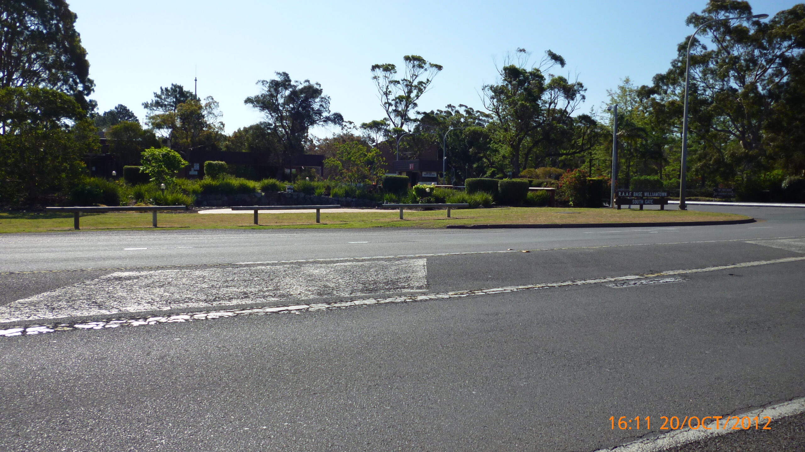 Historical 2012 photograph of RAAF Base Williamtown’s south gate, with its sign beside the entrance road.